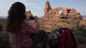 A female hiker admires the dramatic Arches National Park
