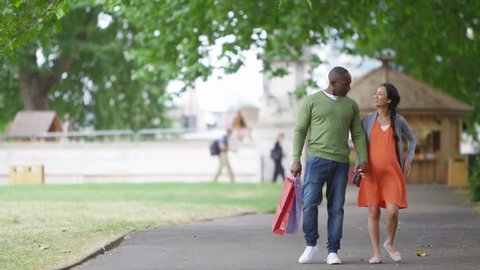 4K Happy mixed ethnicity couple expecting a baby going for a walk in the park. Shot on RED Epic. Stock Video