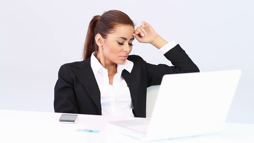 Business woman sitting at the desk and checking her smartphone