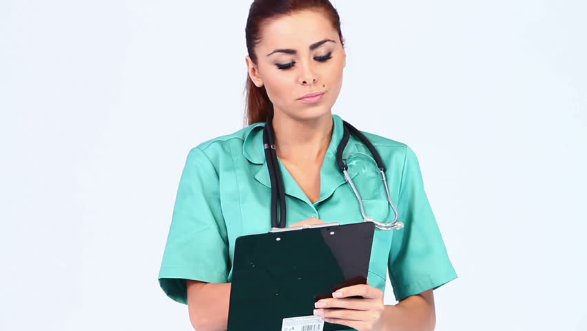 Beautiful female doctor on white background making notes