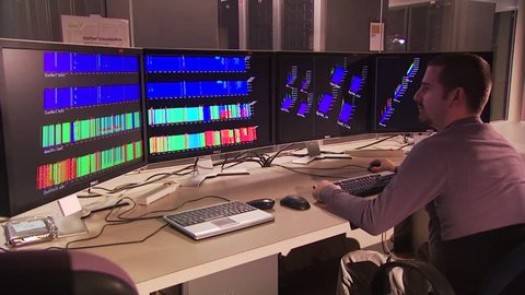 CIRCA 2010s - Researchers sit in a control room looking at computers.
