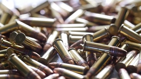 A slow motion dolly shot of a pile of bullets