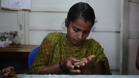 Indian Girl Rolling Handmade Clay Jewellery in her Hand 