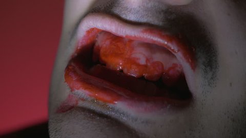 Closeup on the mouth of a zombie with a strobe light and red background. Great Halloween clip to add in you horror, scary, spooky projects.