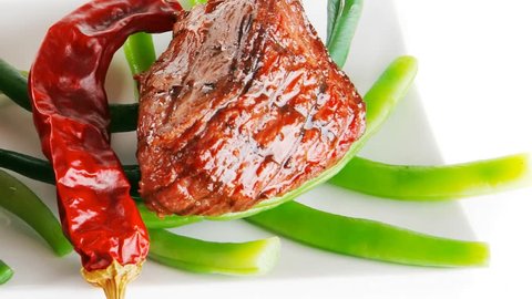 served grilled beef veal fillet entrecote on a white plate with peppers and green peas on long plate 1920x1080 intro motion slow hidef hd