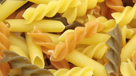 Loopable background of uncooked Italian macaroni pasta.