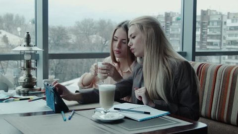 Two freelancer girls designers discuss the project using tablet