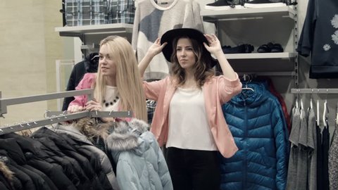 Girlfriends try on a hat in store