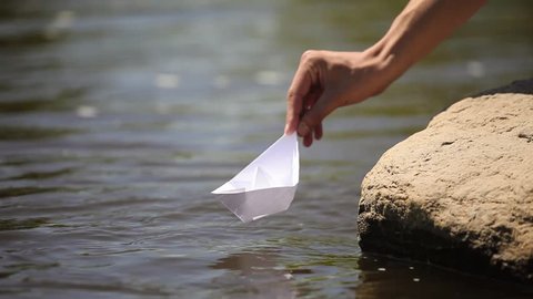 Nature. Green forest with a river. Green forest and river at sunset / sunrise in the fog. Outdoor activities. Green Fields / meadow.The hand of man launches a paper boat.