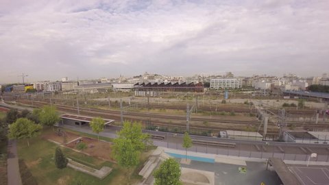 Paris, 18th arrondissement- Aerial view of TGV high speed train passing at Gare du with Halle Pajol and city skyline in background 
