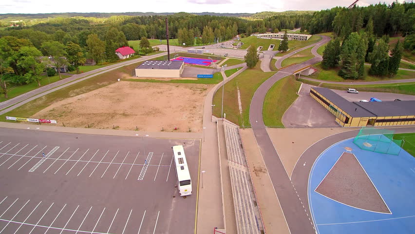 A big white bus arriving on the parking lot at the stadium in Otepaa