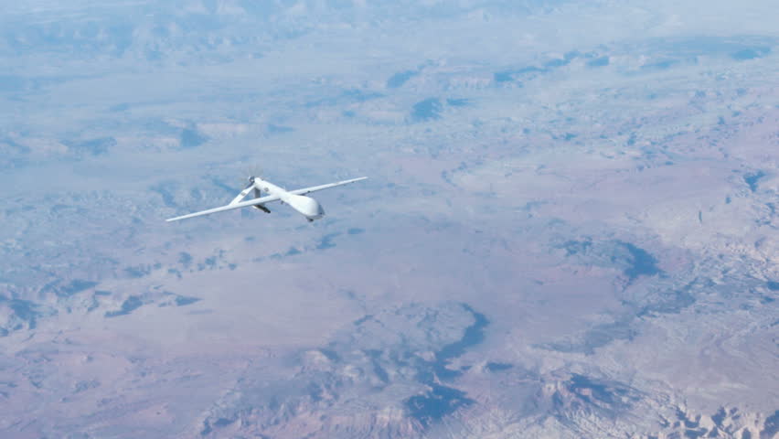 A Predator drone flying at high above the clouds conducting surveillance. 