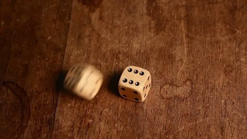 Double six (twelve) is rolled with two wood dices on a wooden table.
