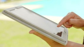 Woman Working on Tablet Device in Swimming Pool Area at Slow Moion Video