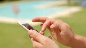 Close Up on Woman Hands While Using Mobile Phone in Outdoor Swimming Pool Area on Slow Motion Video