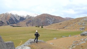 photographer taking a photo on rock cliff of castle hill view point in road to arthur pass national park south island new zealand important destination to visiting