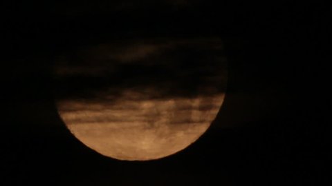 Black clouds on background moon disk