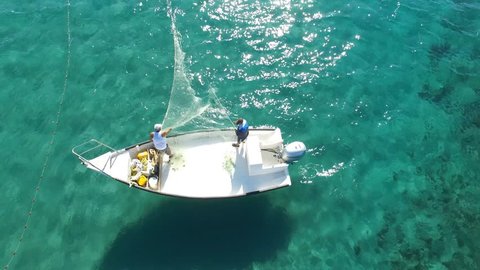 Circa, Circa - November 24 9, 2015:  Aerial footage of men on a small fishing boat deploying a fishing net into the water संपादकीय स्टॉक व्हिडिओ
