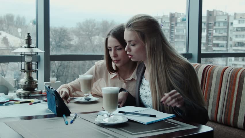 Two freelancer girls designers discuss the project using tablet