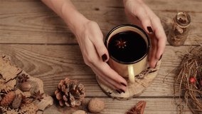 Female hands taking mulled red wine in iron cup. rustic style