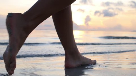 Female Feet Walking Barefoot on Sea Shore at Sunset. Slow Motion. Closeup. HD, 1920x1080.   