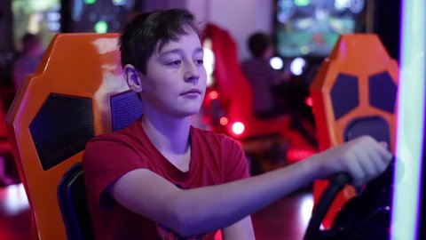 Teenager sits and spins the wheel on the slot machine simulator races