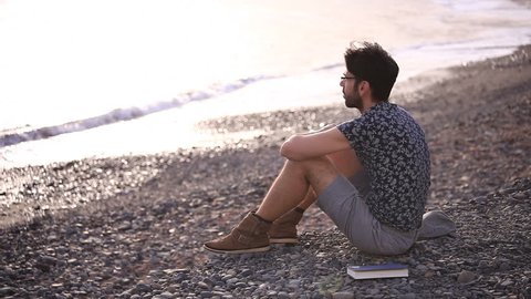 Thinking man relaxing on the beach (copy space, medium shot)