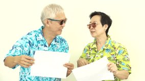 Video Happy Asian senior couple holding white blank sign ready for holiday trip