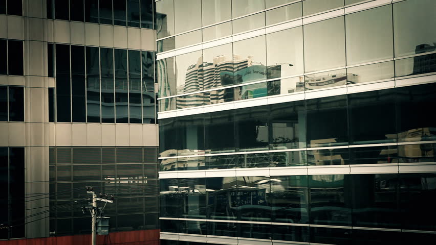 Bangkok city traffic reflected in glass facade of modern buildings