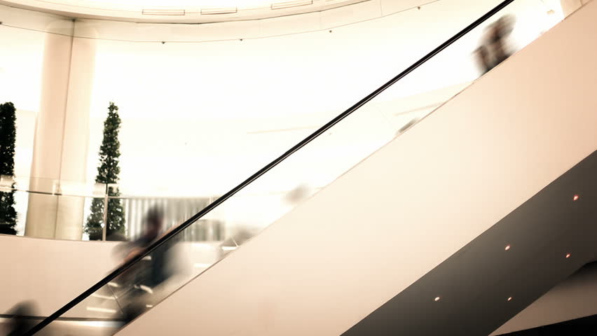 People in shopping mall moving up with escalator shot in time lapse