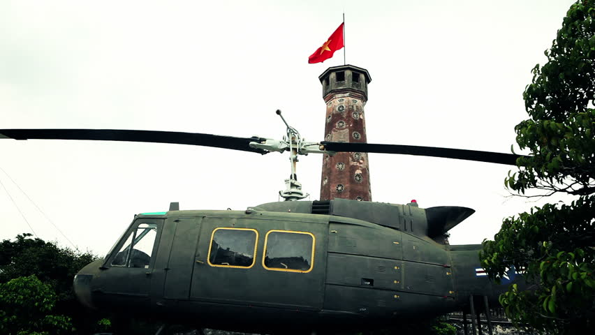Helicopter in front of waving vietnamese flag on top of high tower