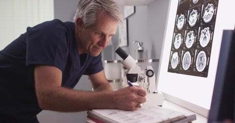 Mature white neurologist male looking at x-rays स्टॉक वीडियो