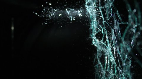 Plate glass window shattering on black from the side, isolated on black breaking in slow motion in 4k 