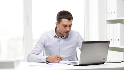 business, people, paperwork and technology concept - busy businessman with laptop computer and papers working in office