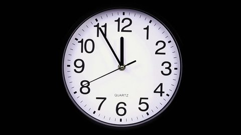 Wall clock on a black background 23:55 hours