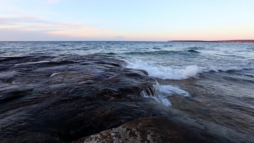 Waves on Lake Superior Shoreline in the Upper Peninsula of Michigan. Waves crash over sandstone rock at Five Mile Point near Christmas Michigan