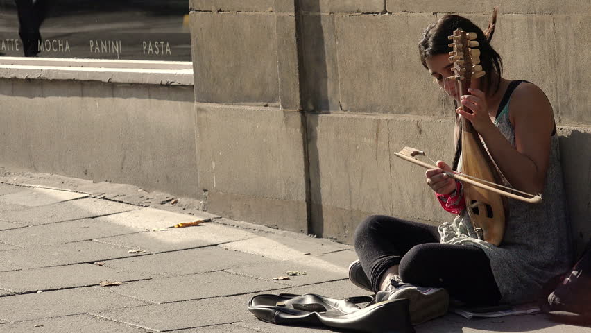beggar woman playing music and asking charity