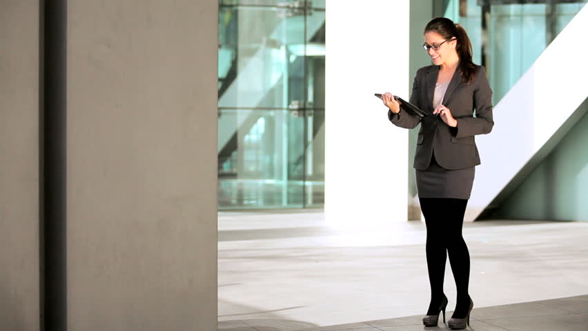 Smart young businesswoman in the atrium of a modern office building using a modern wireless tablet | Shutterstock HD Video #1334566