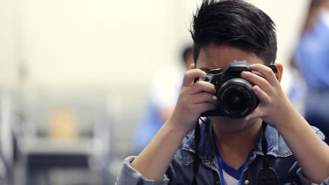 Asian boy looking and shoot with DSLR camera 