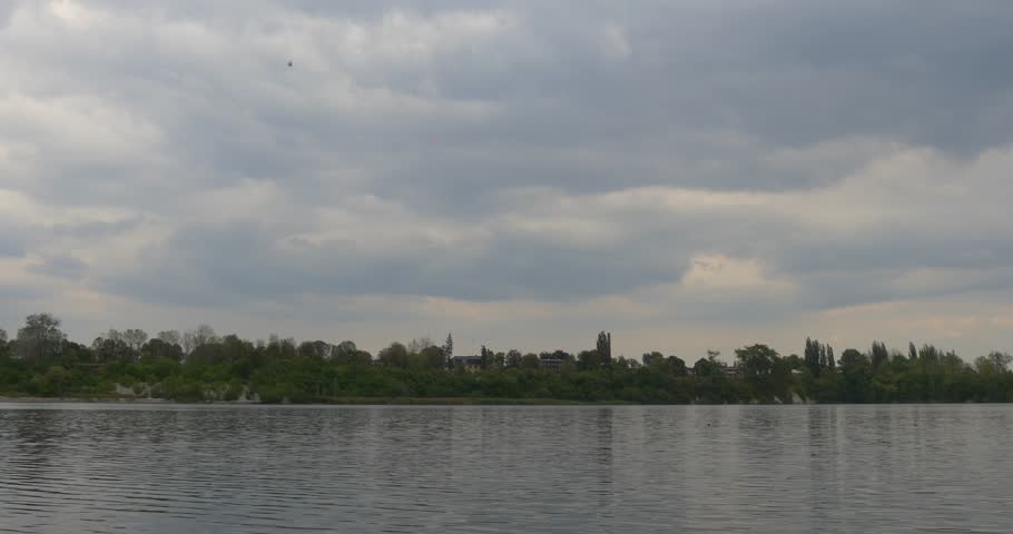 River Lake Pond Rippling Water Close Up, Floating Clouds, Green Trees on a Horizon at Opposite Bank, Cloudy Sky ,Outdoors ,Daytime, Landscape