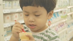 Boy eats ice cream with spoon, retro image video,