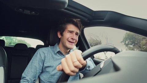Sad desperate man crying while driving car
