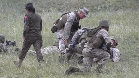 CIRCA 2010s - Mongolian Chinese and U.S. army forces engage in a mock battle on a hillside.