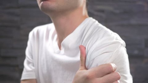 Young adult man showing shoulder pain.