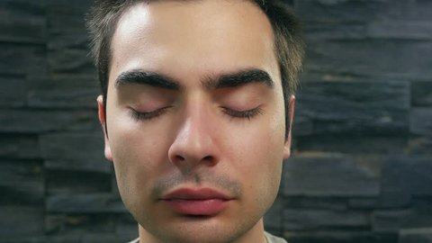 Man opening his eyes and looking directly into the camera lens.