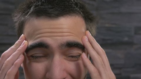 Young adult man Holding his head because of head pain.