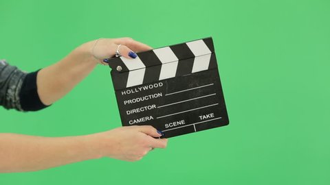 hand girl with clapperboard on the green screen. blue manicure nails