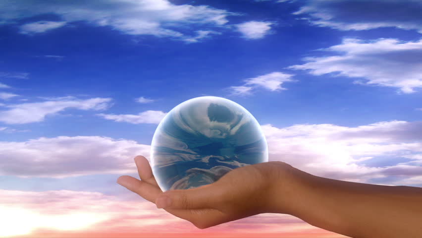 crystal ball in hand against pink and blue clouds 