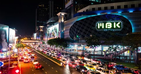 BANGKOK, THAILAND - NOVEMBER 13, 2015: MBK shopping mall in night time with traffic car lights captured by a long exposure image. Time lapse movie.