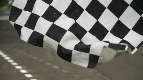 Waving race checkered flag in race track
